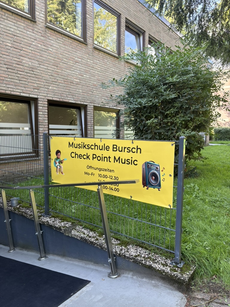 Werbebanner Musikschule Bursch am Gartenzaun montiert