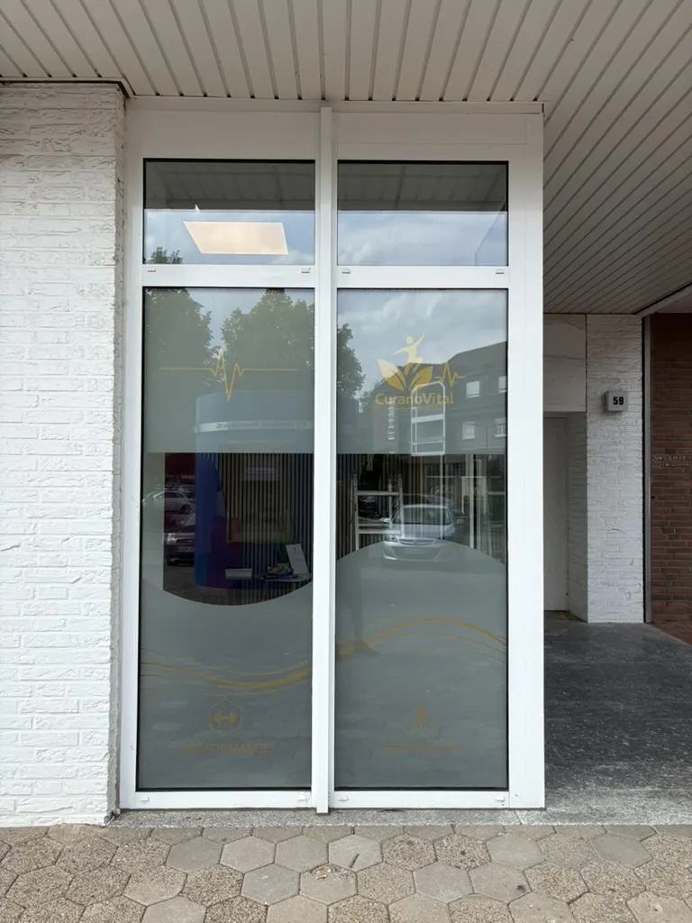 Glastür von CuranoVital mit Sichtschutzfolie und Symbolen