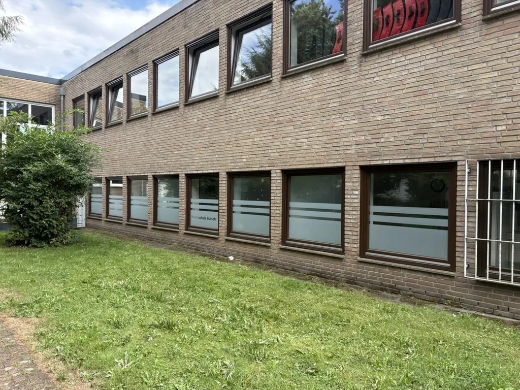 Fensterreihe der Musikschule Bursch mit Sichtschutzfolie in Streifenoptik