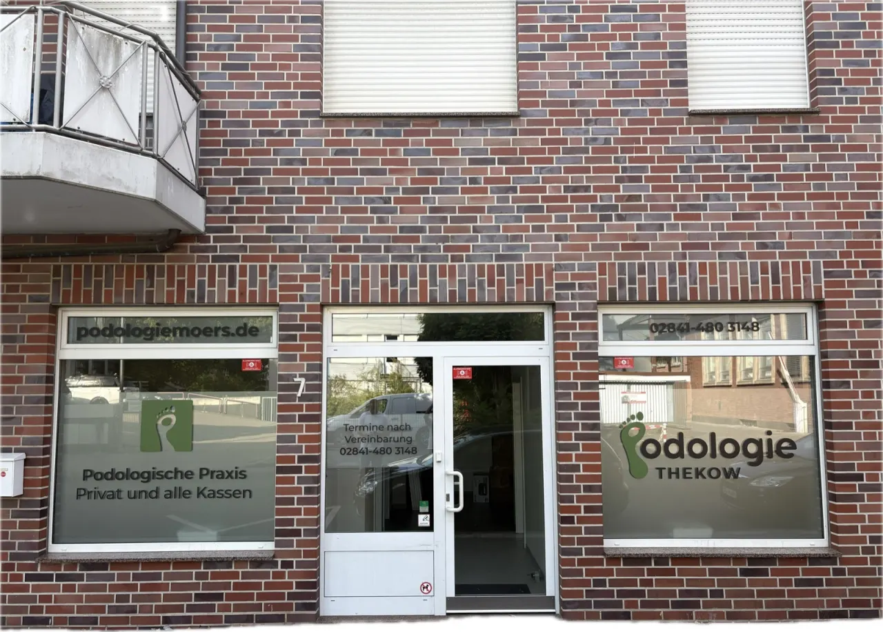 Praxisfront Podologie Thekow in Moers mit Sichtschutzfolie, Logo und Beschriftung an zwei Fenstern und der Tür