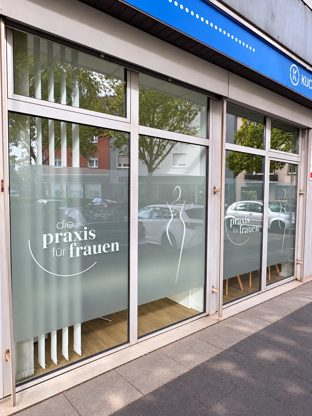 Schrägansicht der Praxisfenster: Logo „die praxis für frauen“ und Silhouette in der Sichtschutzfolie