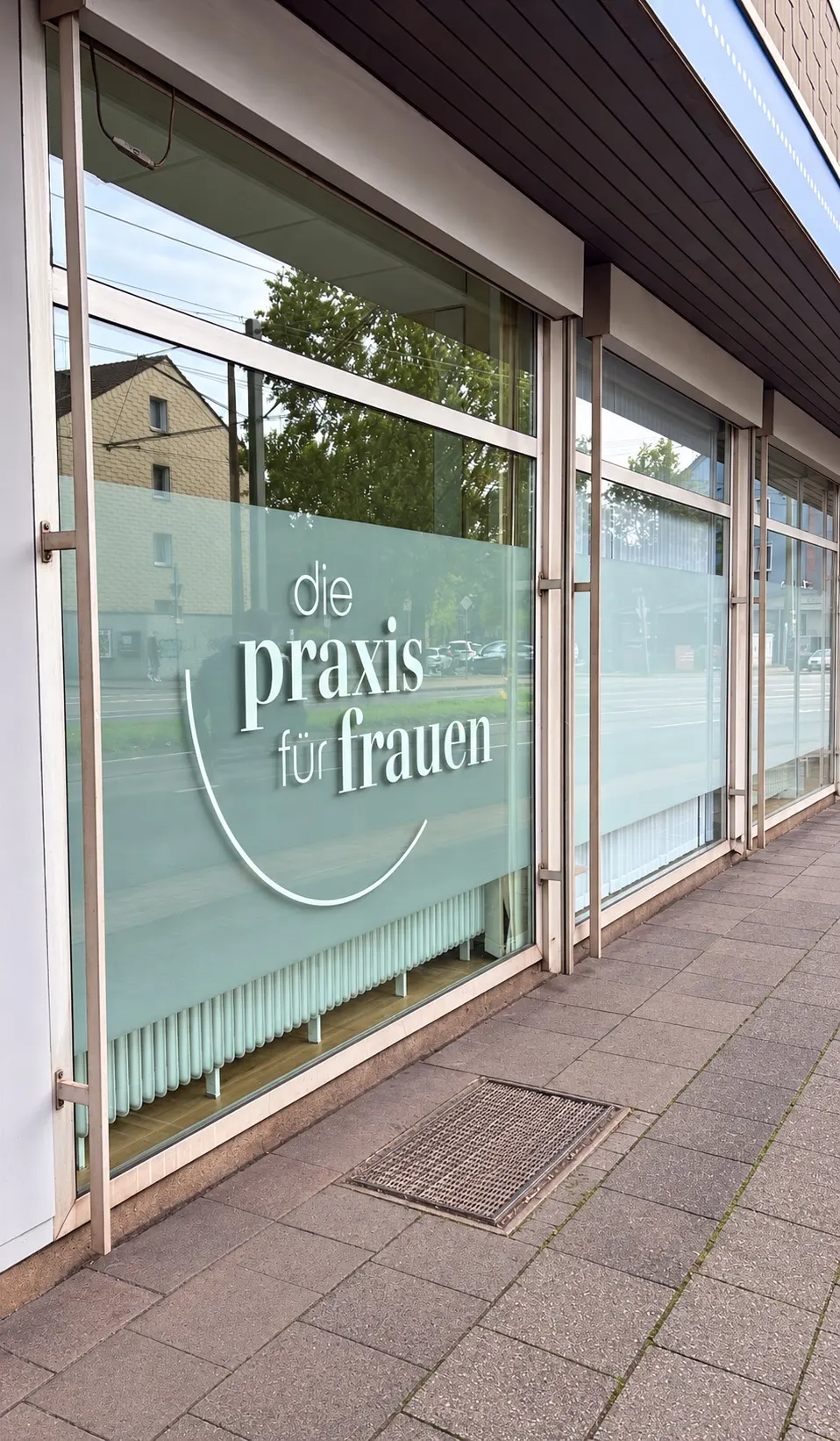 Großes Schaufenster zur Straße mit dem Schriftzug „die praxis für frauen“ in der Sichtschutzfolie